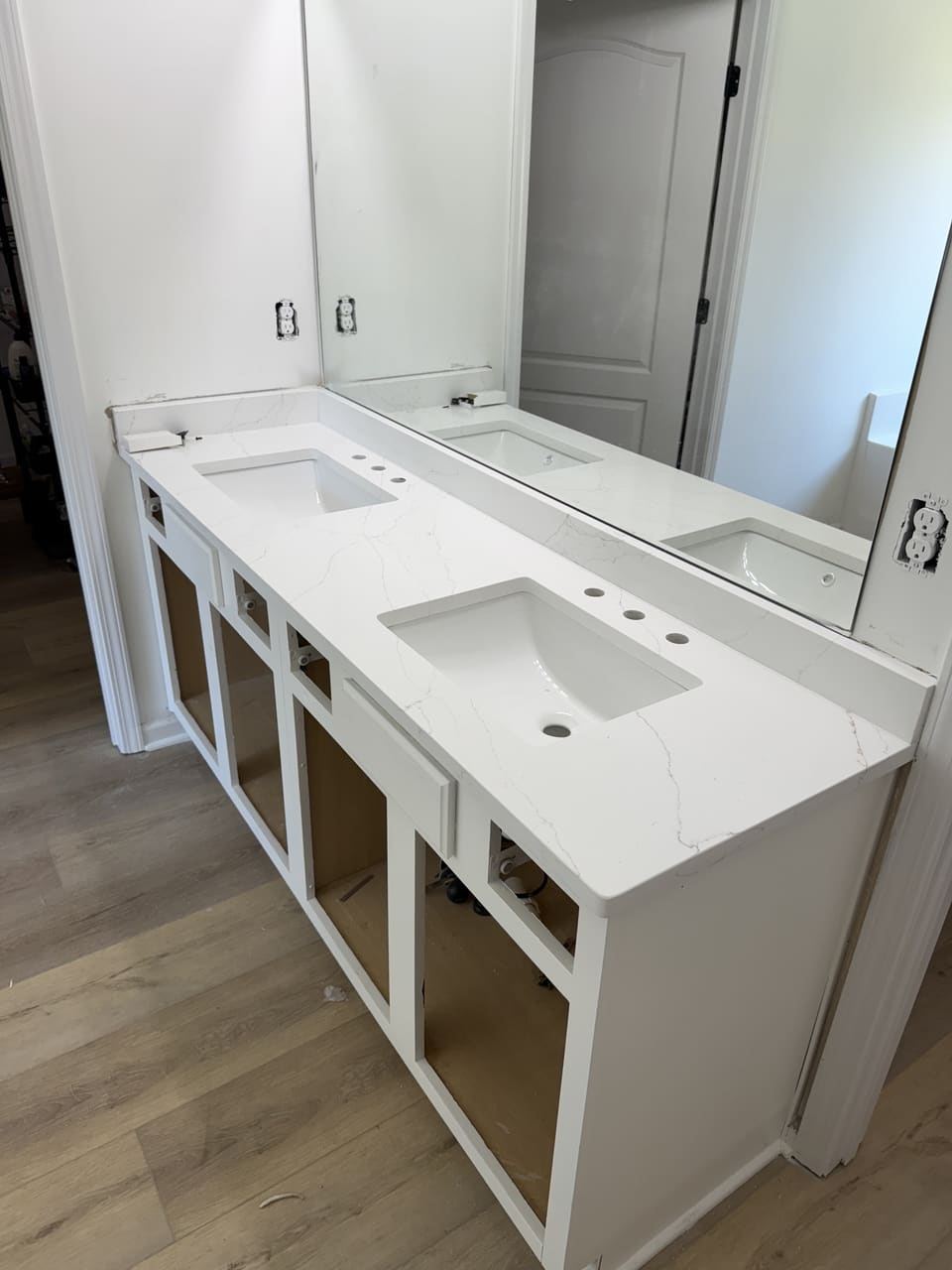White stone double vanity top with two undermount sinks and a tall backsplash