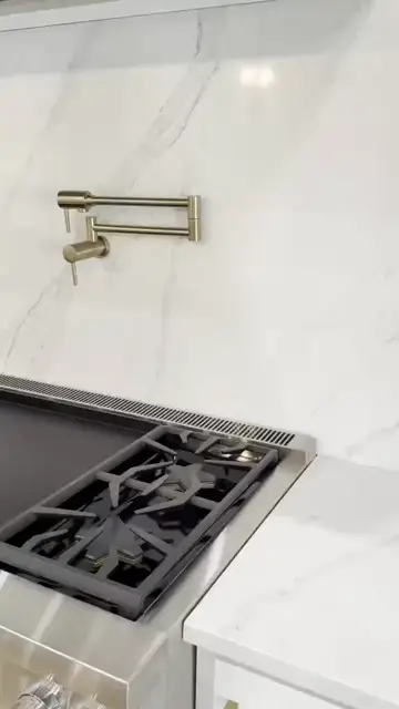 Rangetop and full slab backsplash with a brass pot filler