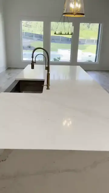 White island with a brass faucet facing the windows